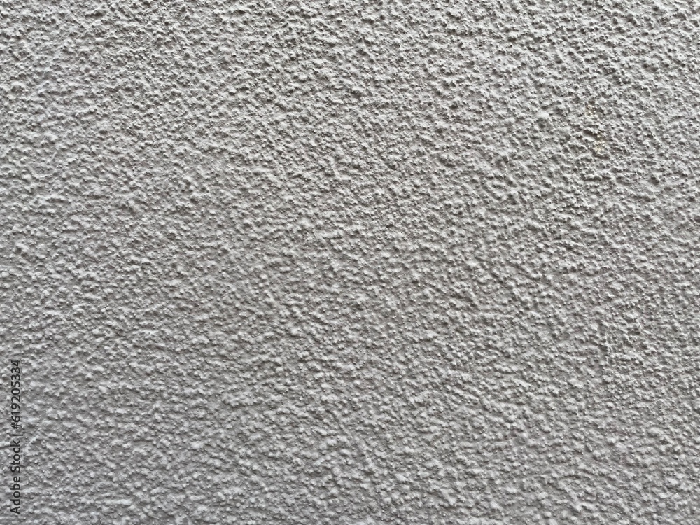 Roughcast surface. Grunge texture as background. Bumpy gray exterior wall with small frequent cracks. Rugged coarse cement or concrete rendering. Painted pebble dash. Uneven structural plaster finish. Roughcast surface. Grunge texture as background. Bumpy gray exterior wall with small frequent cracks. Rugged coarse cement or concrete rendering. Painted pebble dash. Uneven structural plaster finish.