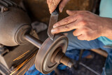 Knife sharpening work. hands with a knife, close-up shot of a man's hands sharpening a knife with a grinding wheel