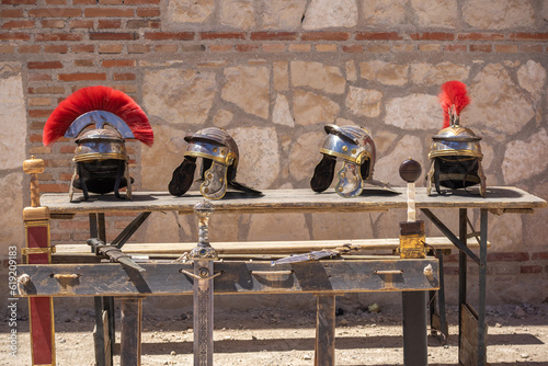 outdoor display of soldier helmets and swords from the ancient roman empire
