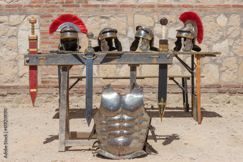 outdoor display of helmets, swords and cuirass of soldiers from the ancient roman empire