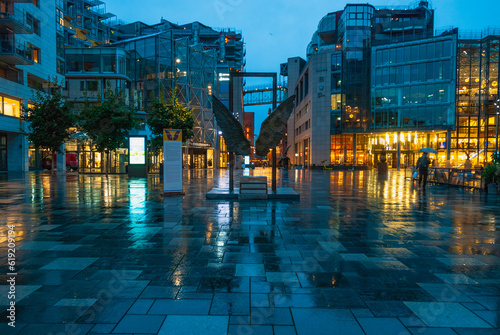Illuminated Akker Brygge, a modern district in Oslo city center at night and in the rain, Norway