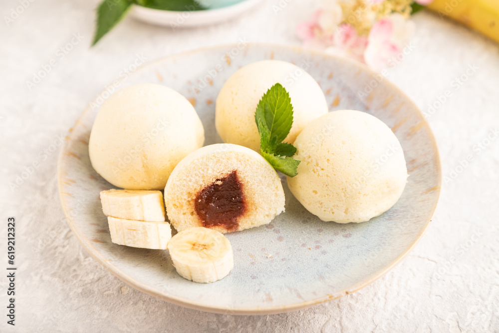 Japanese rice sweet buns mochi filled with jam on a gray concrete. side view, selective focus. Japanese rice sweet buns mochi filled with jam on a gray concrete. side view, selective focus.