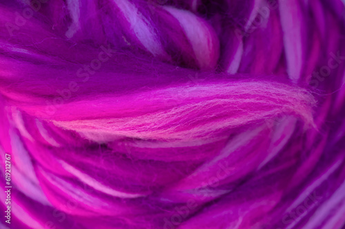 Multicolored pink, magenta strings of wool for felting and spinning as a background. 