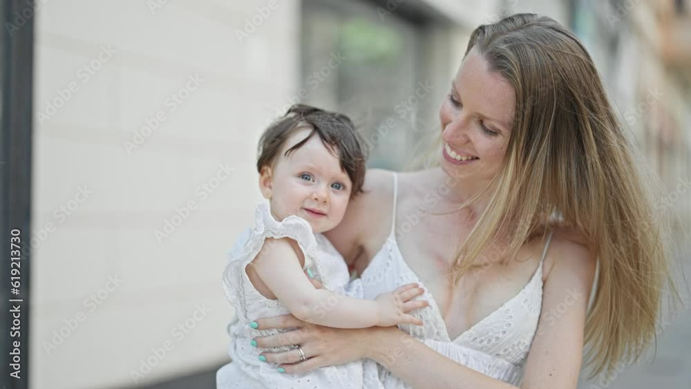 Mother and daughter hugging each other smiling at street Mother and daughter hugging each other smiling at street