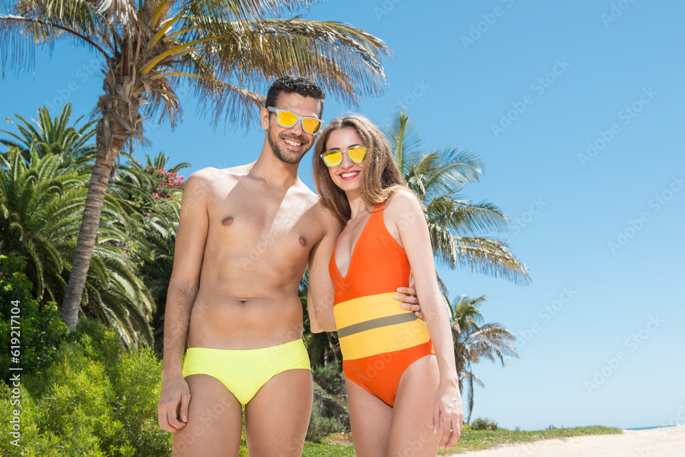 Young couple in swimsuits in the morning sun in a coastal area