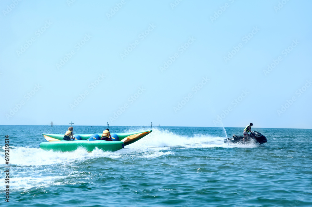 Fototapeta premium Walk on an inflatable mattress at ocean on a tow of a water motorcycle