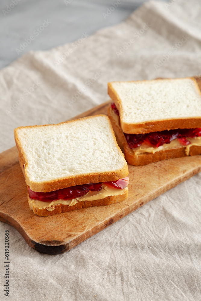 Homemade Peanut Butter and Jelly Sandwich on a rustic wooden board, side view. Homemade Peanut Butter and Jelly Sandwich on a rustic wooden board, side view.