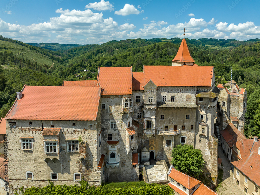 Aerial view of Pernstejn castle with Gothic palace red roof, rectangular and round towers, barbican, forward gun platform in Moravia