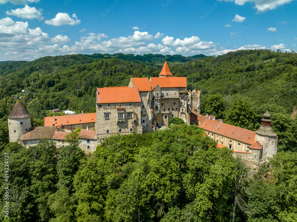 Aerial view of circular corner defensive tower and Gothic palace building at Pernstejn castle