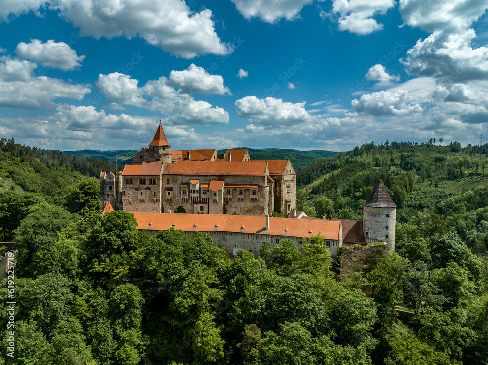 Aerial view of circular corner defensive tower and Gothic palace building at Pernstejn castle