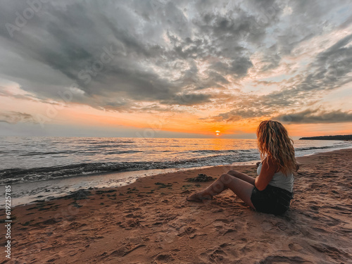 Woman on beach at sunset, enjoying nature, relaxation, and serenity. © indars18