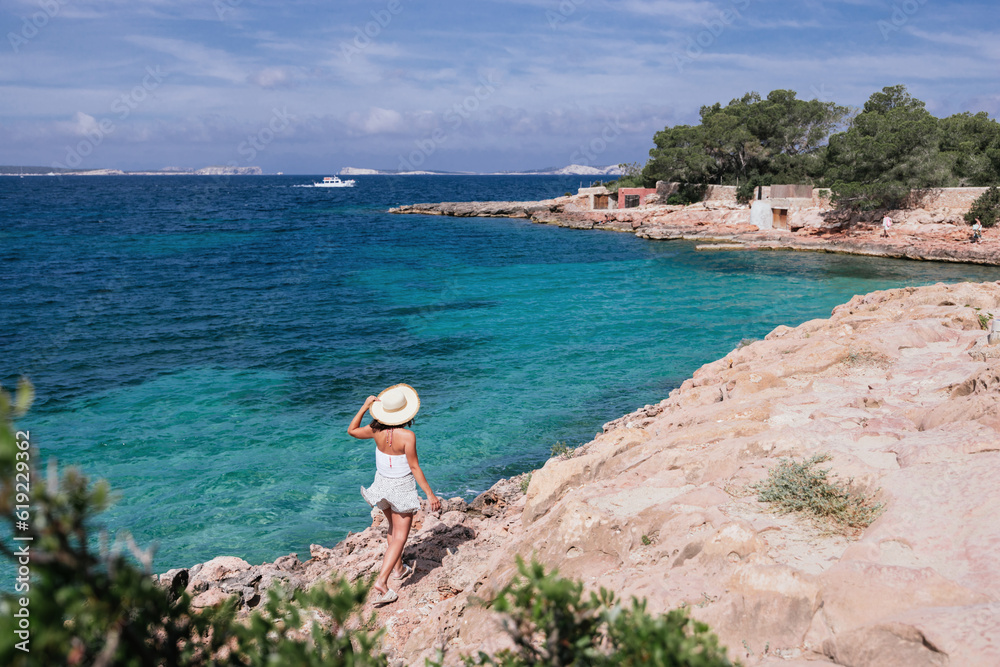 Carefree woman walking on rocky cliff near ocean Carefree woman walking on rocky cliff near ocean