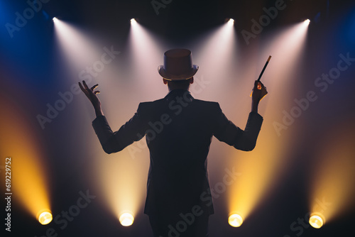 Man with magic wand on stage in spotlight photo