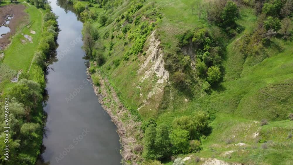 Drone flight over a beautiful river in the Ukrainian province. Chalk hills and green vegetation are visible on the shore.