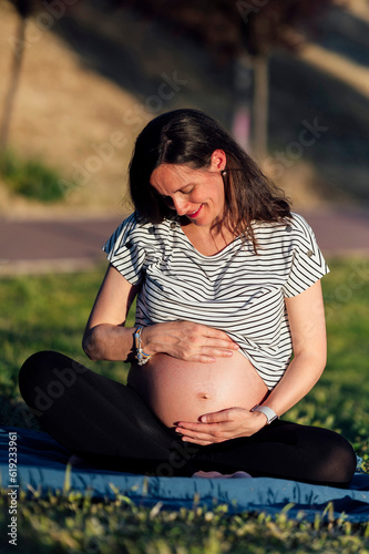 Pregnant woman sitting on picnic blanket