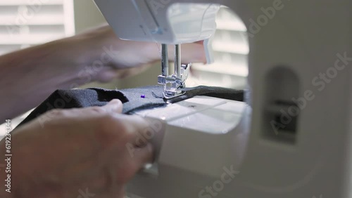 tailor sewing the new pants hem