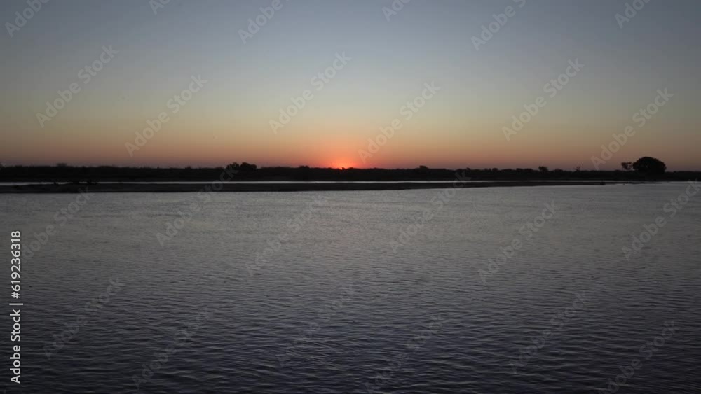 Panorama view of the river and sun hiding in the horizon at sunset. Panorama view of the river and sun hiding in the horizon at sunset.