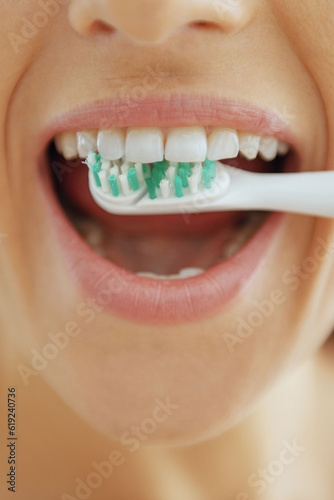 Closeup on woman brushing teeth