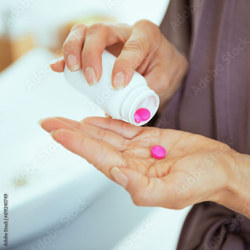 Closeup on young woman with pills