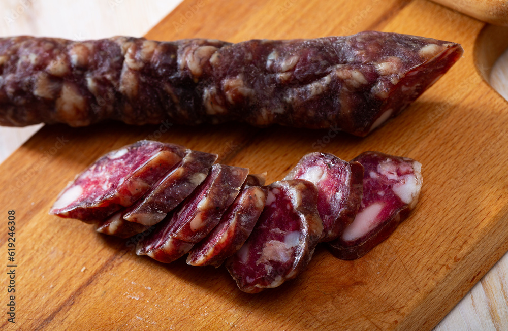 Traditional French dried sausage on cutting board