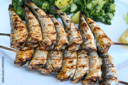 Grilled pilchard. Tasty Sardines served on plate in restaurant. Delicious fish on barbeque.