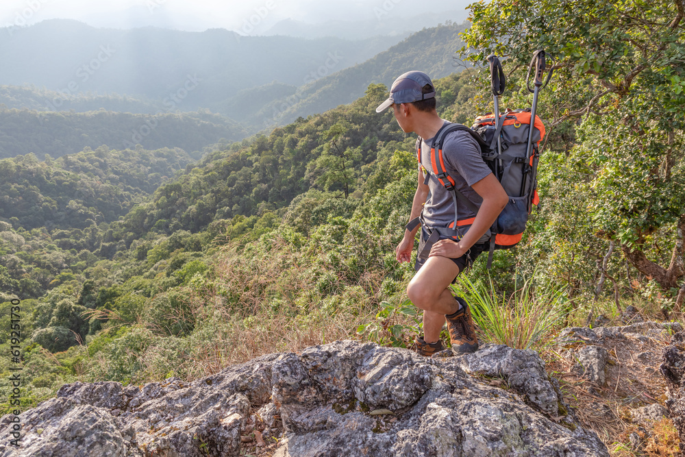 Male hiker with backpack walking on top rock mountain landscape and beautiful view .Hiker men's hiking living healthy active lifestyle. Male hiker with backpack walking on top rock mountain landscape and beautiful view .Hiker men's hiking living healthy active lifestyle.