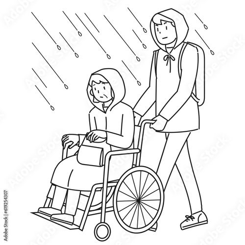 雨の中を避難する車椅子に乗った高齢女性と支援する男性