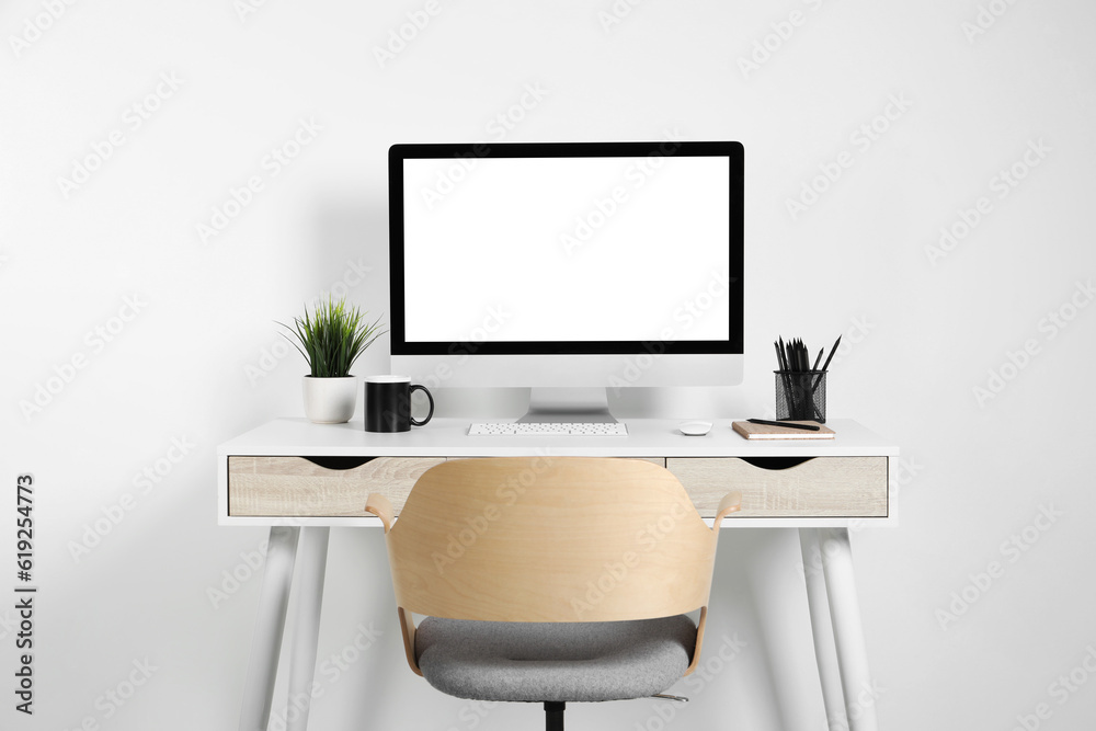 Cozy workspace with computer, houseplant and stationery on wooden desk at home Cozy workspace with computer, houseplant and stationery on wooden desk at home