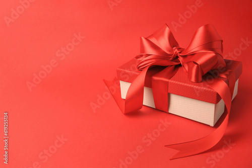 Beautiful gift box with bow on red background. Space for text © New Africa