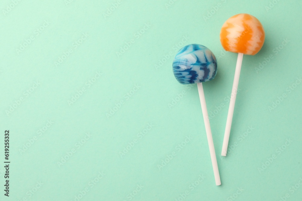 Tasty lollipops on turquoise background, flat lay. Space for text Tasty lollipops on turquoise background, flat lay. Space for text