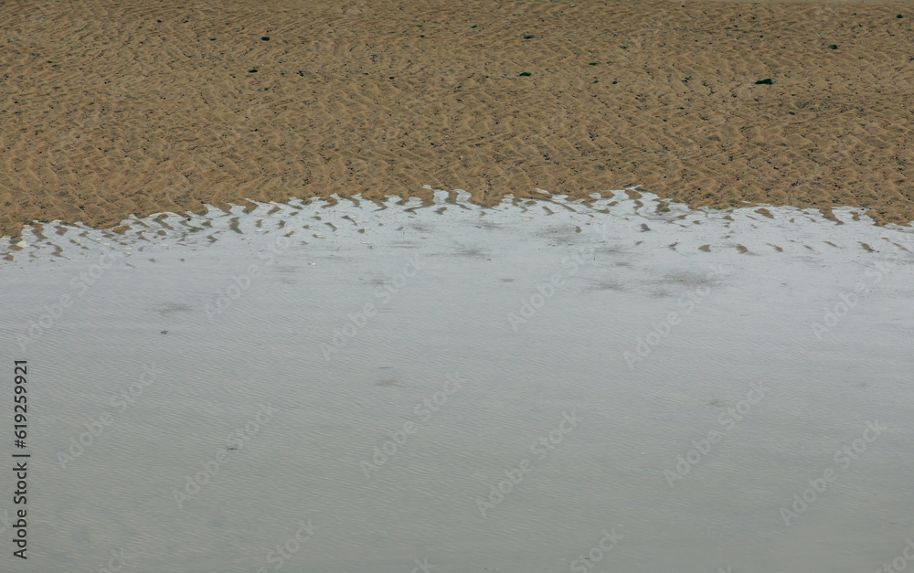 gros plan sur la plage d'un fleuve lors d'une marée basse avec le sable visible et l'eau qui monte doucement gros plan sur la plage d'un fleuve lors d'une marée basse avec le sable visible et l'eau qui monte doucement