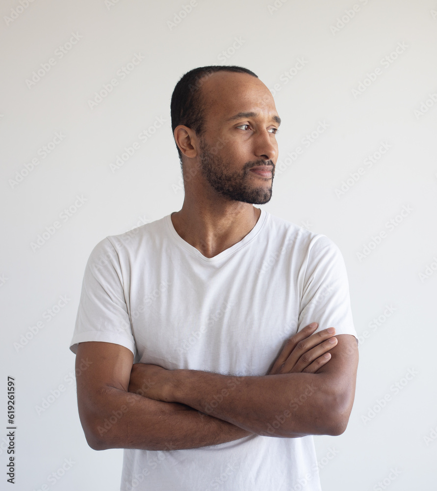 Portrait of laughing young afro american model standing with arms crossed against white background Portrait of laughing young afro american model standing with arms crossed against white background