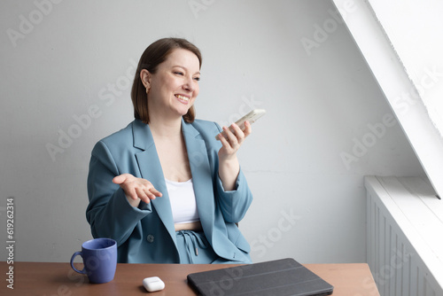 Happy woman talking on mobile phone near window photo