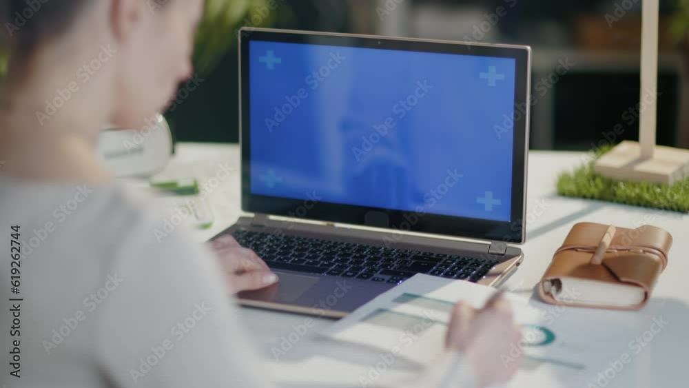 Seen from behind modern business woman with calculator, documents and laptop in modern office. Seen from behind modern business woman with calculator, documents and laptop in modern office.