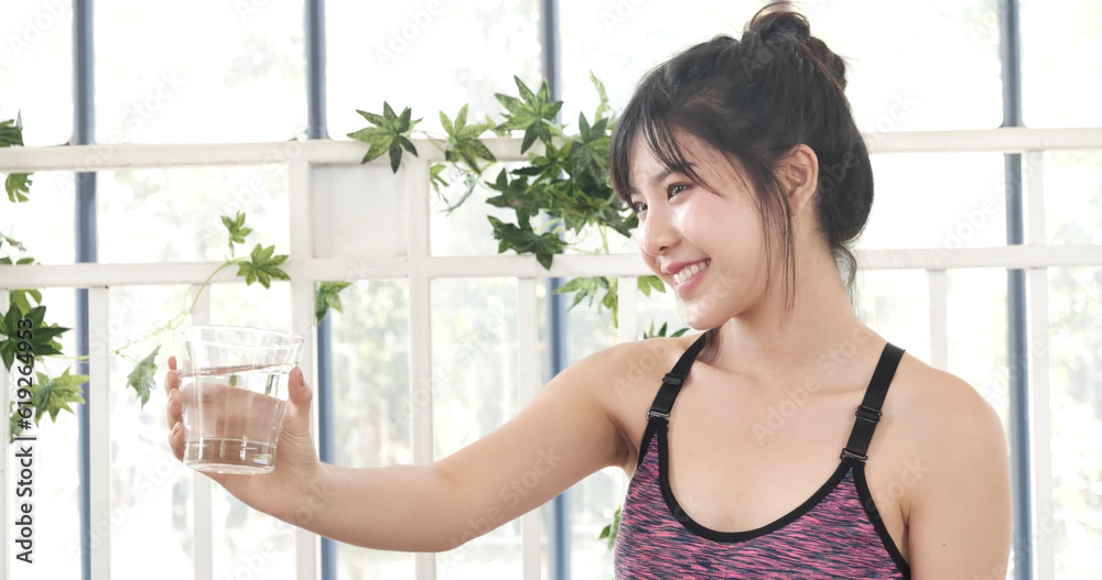 Woman drinking water hands holding cold mineral water cool drinking. Asian women smile laugh look away health care home fitness lifestyle. Cheerful Beautiful female drink glass of water smile face Woman drinking water hands holding cold mineral water cool drinking. Asian women smile laugh look away health care home fitness lifestyle. Cheerful Beautiful female drink glass of water smile face