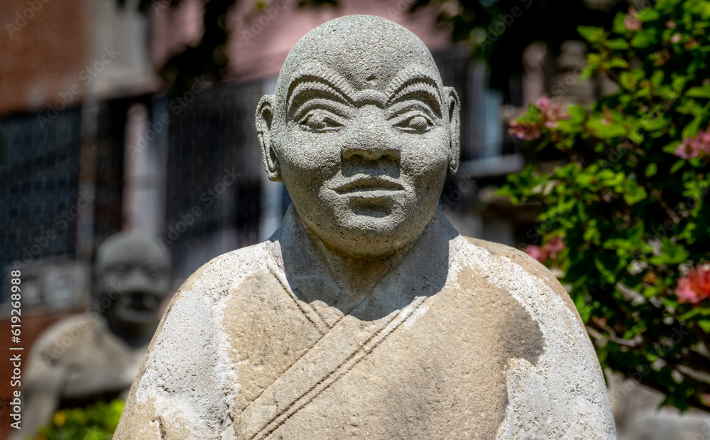 Statue in a garden at the Wat Suthat Buddhist Temple in Bangkok
