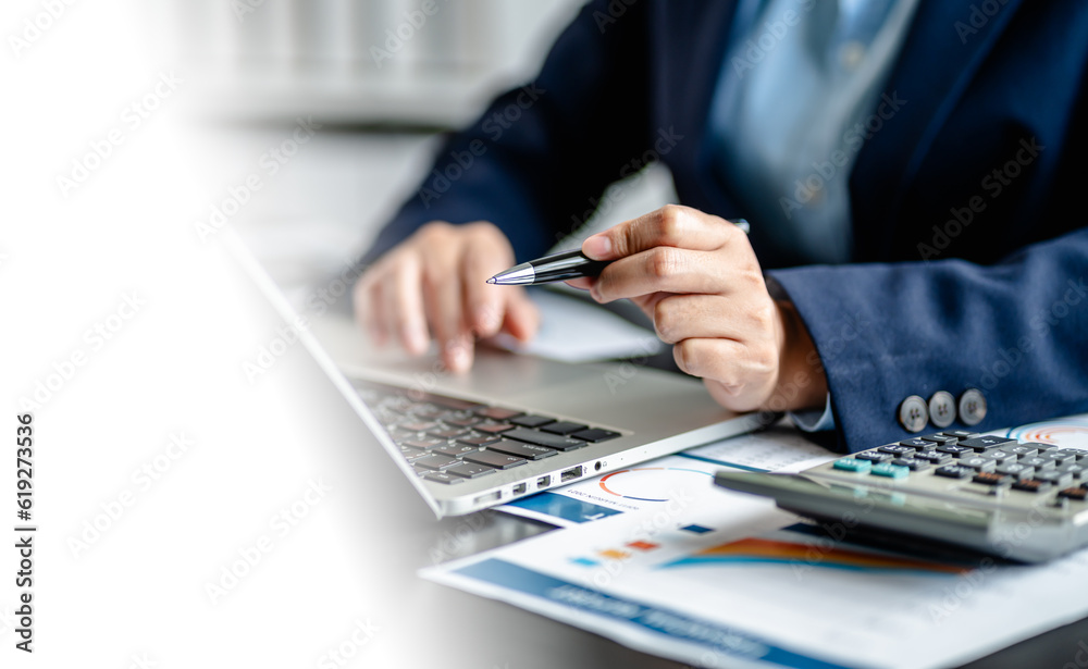 Close up of Businesswomen or Accountant working on laptop computer with analytic business report graph and finance chart at the workplace, financial and investment concept. Close up of Businesswomen or Accountant working on laptop computer with analytic business report graph and finance chart at the workplace, financial and investment concept.