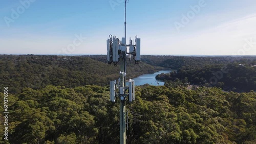 Aerial drone rotation view circling a mobile telecommunication cell tower on a panoramic countryside landscape background at Jannali in southern Sydney, NSW Australia 