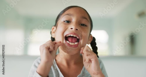 Girl child, floss and cleaning for dental hygiene, healthcare and wellness for healthy smile, tooth or mouth. Young female kid, teeth whitening and happy for oral self care in morning at family home photo