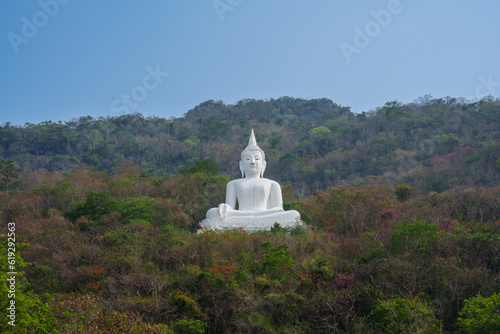 Big white Buddha statue on the mountain.
