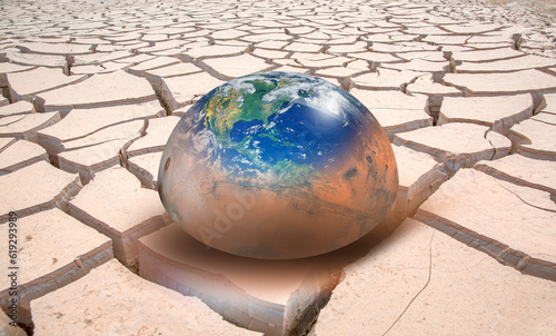 Global warming concept - Planet Earth on dry soil with planet of Mars "Elements of this image furnished by NASA "