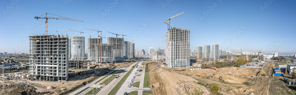 wide aerial panoramic view of construction site of the new neighborhood. urban real estate landscape on blue sky background.