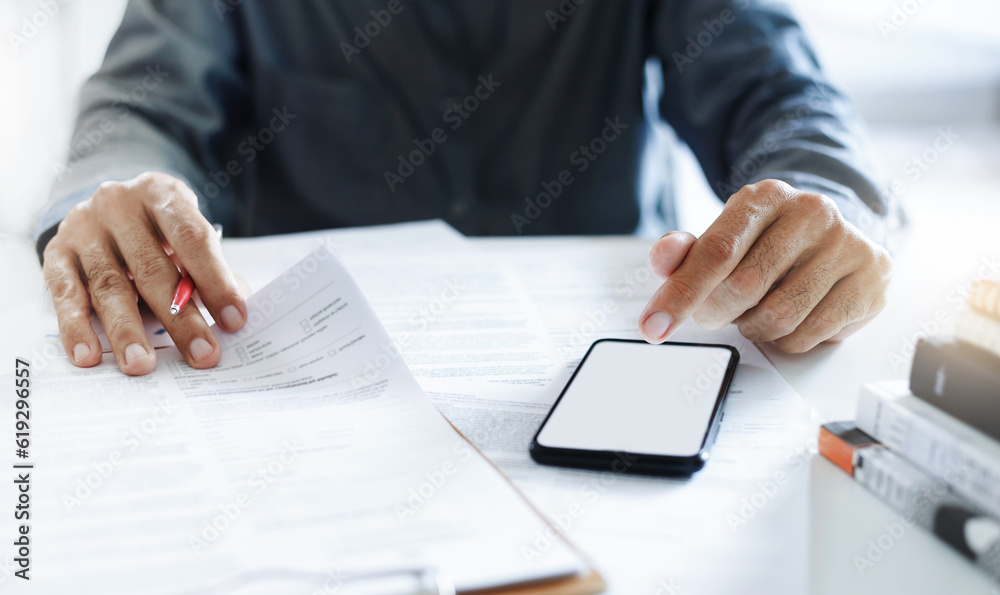 Asian businessman start new business SME and using smart phone to searching data from internet about new business he is interested and learning information from the required documents Asian businessman start new business SME and using smart phone to searching data from internet about new business he is interested and learning information from the required documents