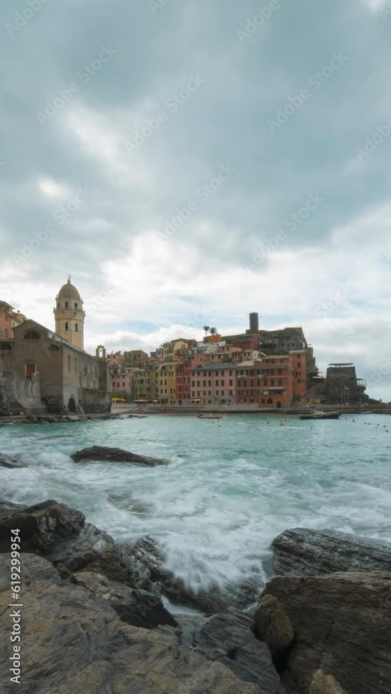 Vertical time lapse shot of Vernazza, Italy Colorful Cliffside Town the Seaside Mountainous of famous Cinque Terre, Liguria, Northern Italia on Tyrrhenian sea in summer day. Coastal travel village. Vertical time lapse shot of Vernazza, Italy Colorful Cliffside Town the Seaside Mountainous of famous Cinque Terre, Liguria, Northern Italia on Tyrrhenian sea in summer day. Coastal travel village.