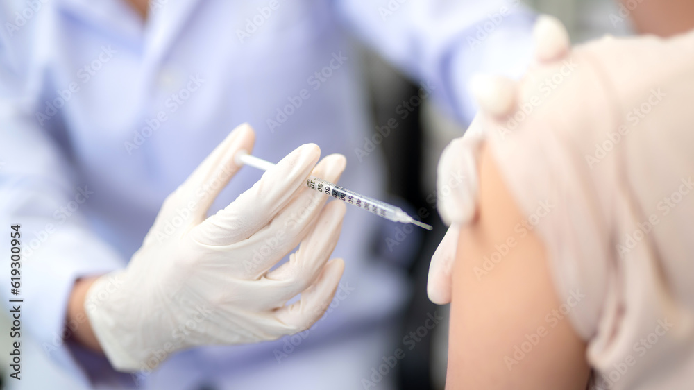 Close up of doctor making a vaccination in the shoulder of patient, Flu Vaccination Injection on Arm. covid-19 vaccine disease preparing for human clinical trials vaccination shot. Close up of doctor making a vaccination in the shoulder of patient, Flu Vaccination Injection on Arm. covid-19 vaccine disease preparing for human clinical trials vaccination shot.