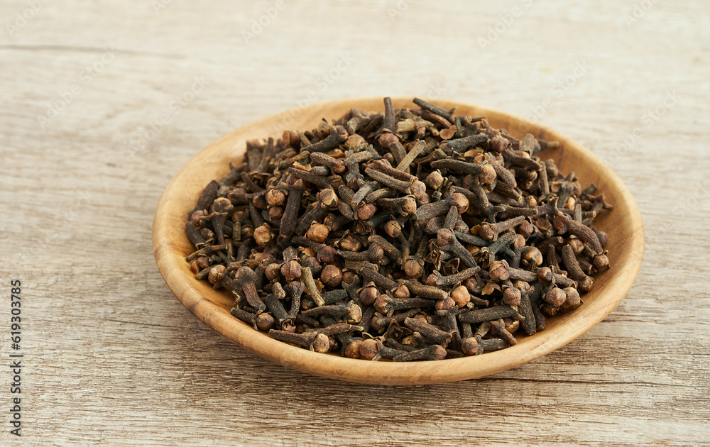 dry clove spice in wood bowl on table background. dry clove spice background. pile of dry clove spice in wood bowl food table background dry clove spice in wood bowl on table background. dry clove spice background. pile of dry clove spice in wood bowl food table background