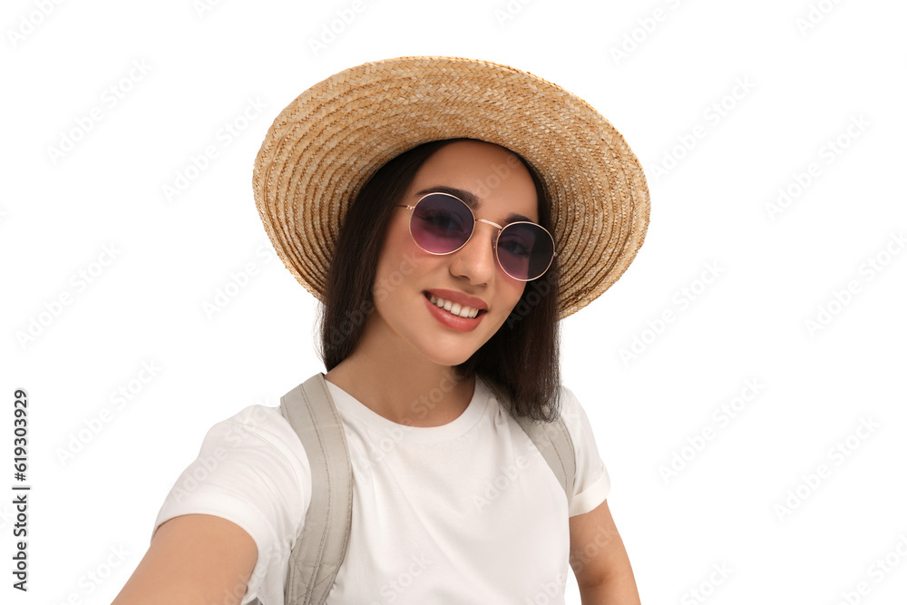 Smiling young woman in sunglasses and straw hat taking selfie on white background Smiling young woman in sunglasses and straw hat taking selfie on white background