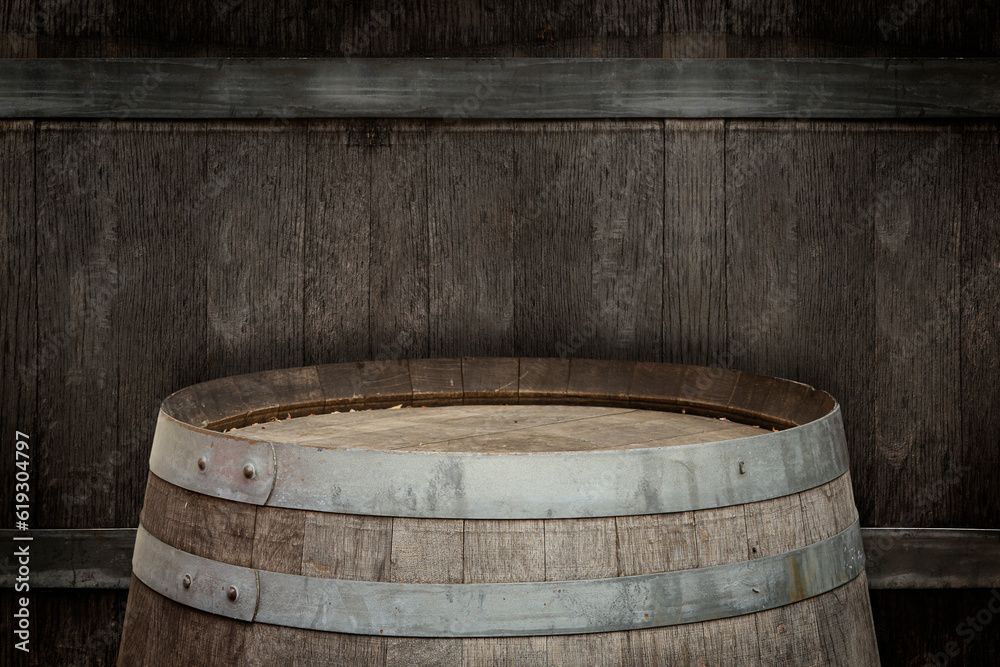 One wooden barrel near textured wall, closeup One wooden barrel near textured wall, closeup