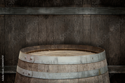 One wooden barrel near textured wall, closeup