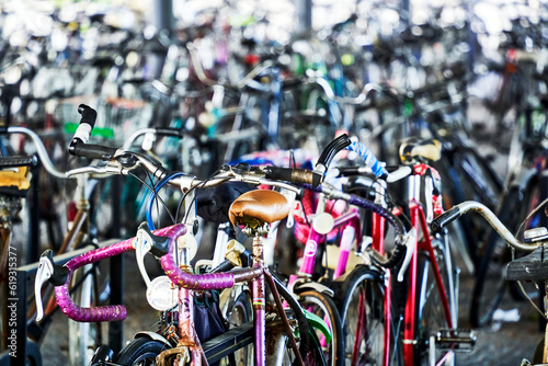 Large number of old colorful bicycles in a parking lot in front of a train station, selective focus